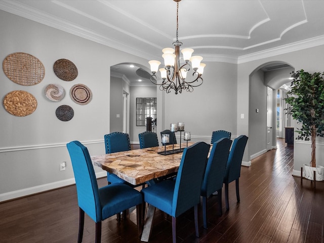 dining area featuring dark hardwood / wood-style floors, a healthy amount of sunlight, ornamental molding, and an inviting chandelier