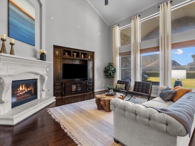 living room featuring hardwood / wood-style flooring, high vaulted ceiling, and crown molding