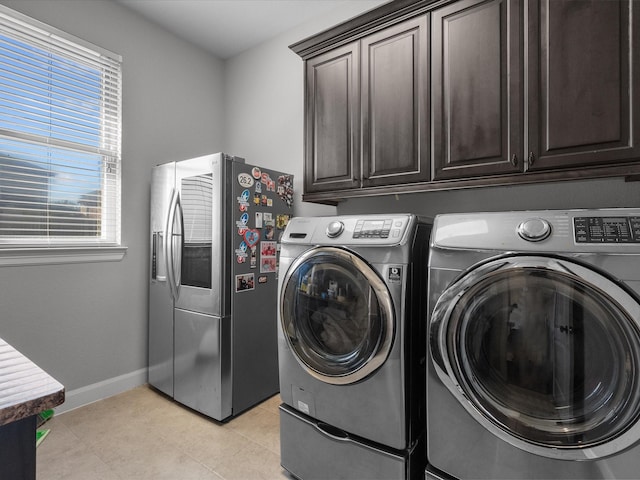 clothes washing area featuring cabinets and washing machine and dryer