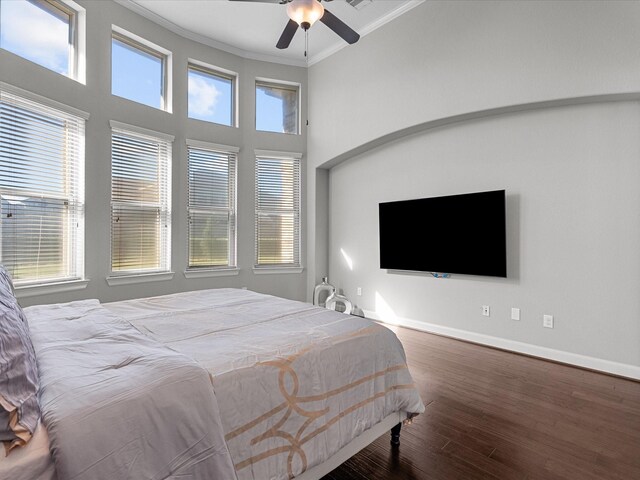 bedroom with hardwood / wood-style floors, ceiling fan, and crown molding