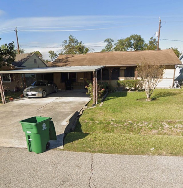 ranch-style home featuring a front lawn and a carport