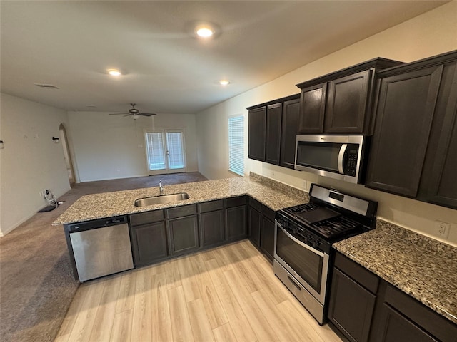 kitchen with kitchen peninsula, stainless steel appliances, light hardwood / wood-style floors, and sink