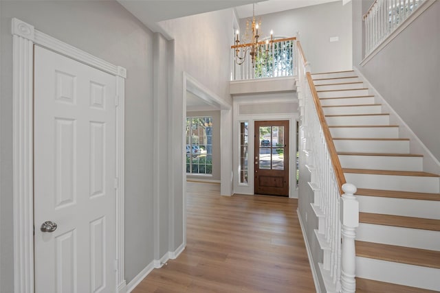 foyer entrance with a chandelier, a high ceiling, and light hardwood / wood-style floors