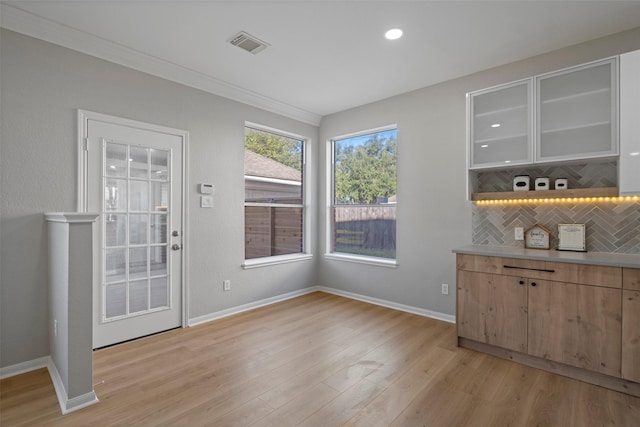 interior space with decorative backsplash, light brown cabinets, and light wood-type flooring