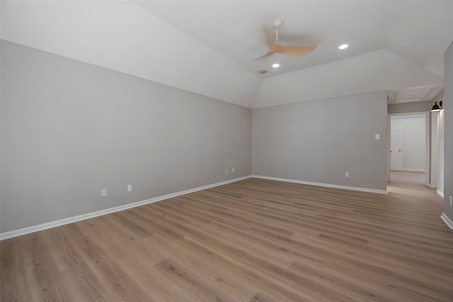 unfurnished room featuring ceiling fan, vaulted ceiling, and light wood-type flooring