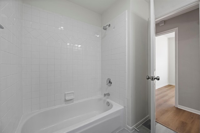 bathroom featuring hardwood / wood-style floors and  shower combination