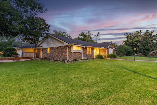 ranch-style home with a lawn