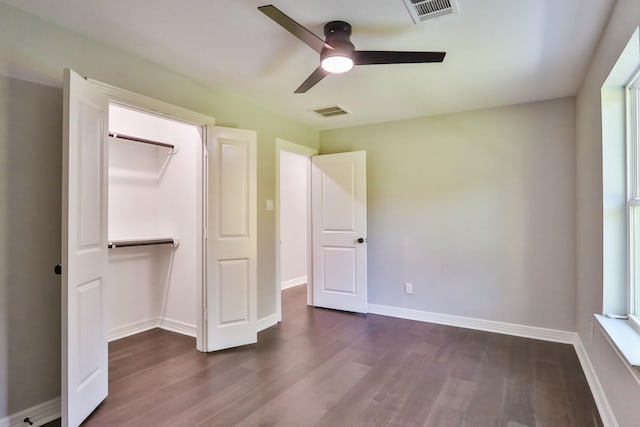 unfurnished bedroom featuring ceiling fan, dark wood-type flooring, and a closet