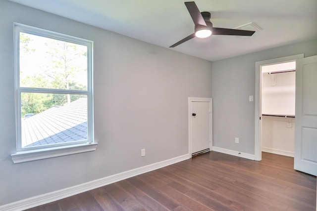 unfurnished bedroom with a closet, ceiling fan, and dark wood-type flooring