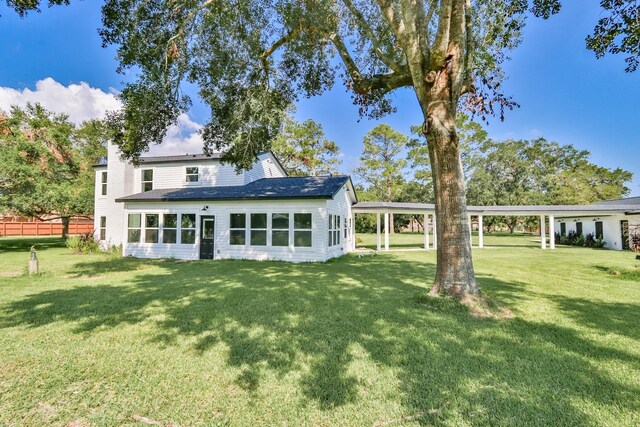 rear view of property with a yard