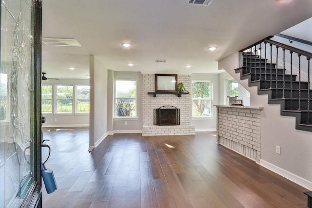 unfurnished living room with dark wood-type flooring and a fireplace