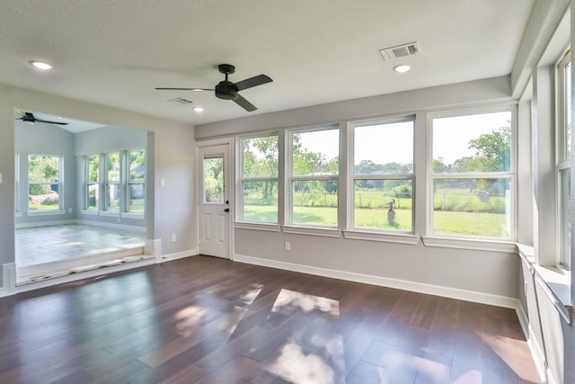 unfurnished sunroom featuring ceiling fan