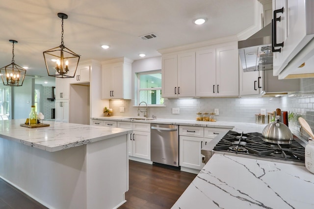 kitchen featuring stainless steel dishwasher, white cabinets, light stone countertops, and hanging light fixtures