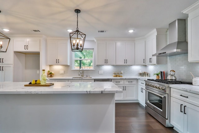 kitchen featuring white cabinetry, sink, wall chimney exhaust hood, light stone countertops, and high end stainless steel range oven