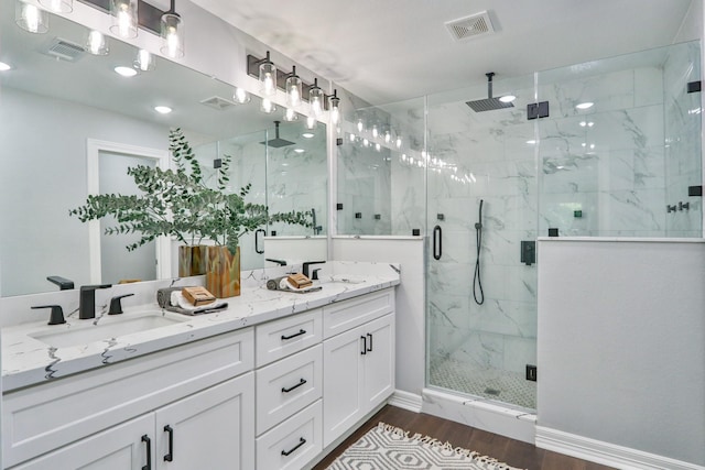 bathroom featuring vanity, hardwood / wood-style flooring, and a shower with door