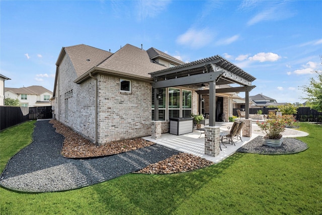 back of property with a pergola, ceiling fan, a lawn, and a patio