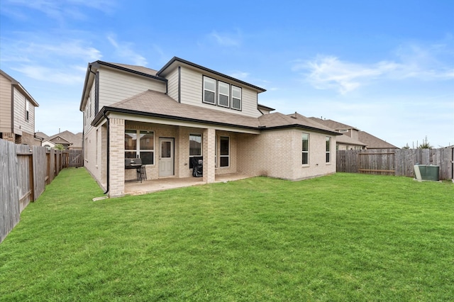 rear view of property with a lawn and a patio area