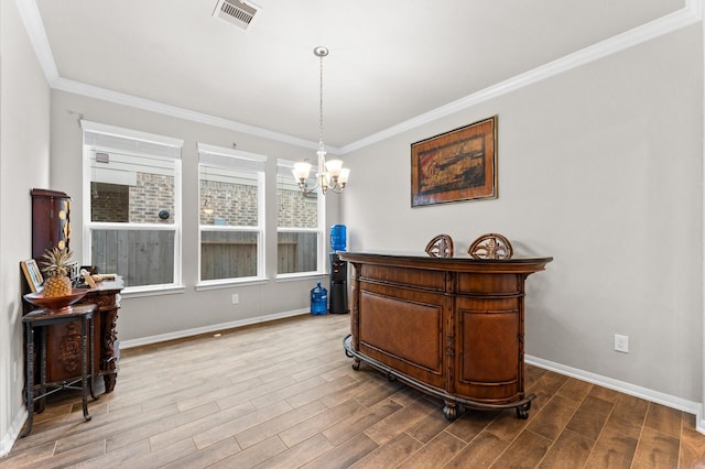 dining room with ornamental molding and a notable chandelier