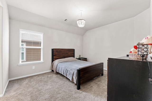 bedroom featuring a chandelier, light colored carpet, and lofted ceiling