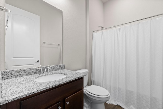 bathroom with hardwood / wood-style floors, vanity, and toilet