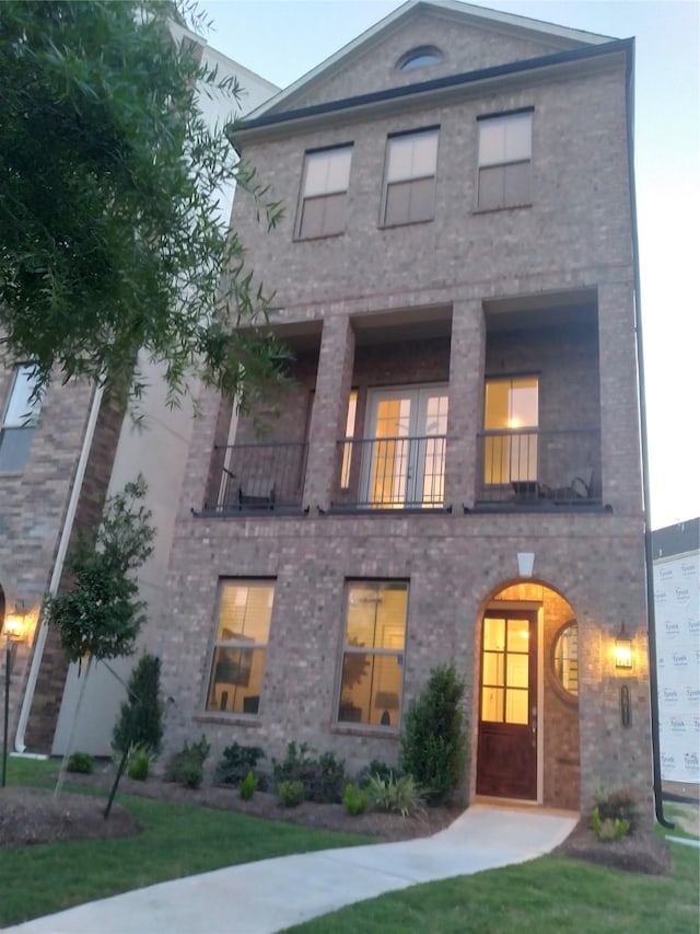 view of front of house featuring a front yard and a balcony