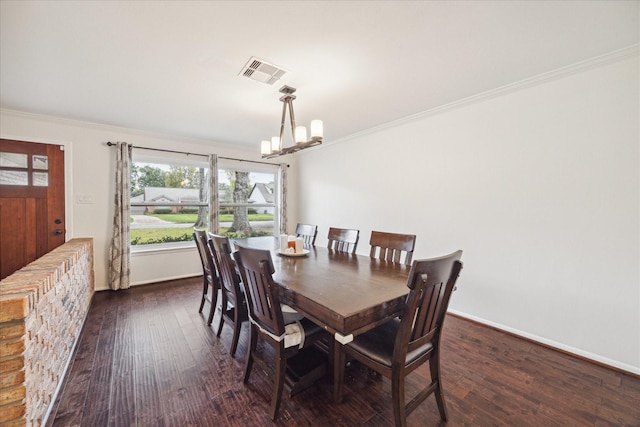 dining room with dark hardwood / wood-style flooring, an inviting chandelier, and ornamental molding