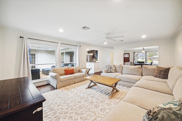 living room featuring hardwood / wood-style flooring, ceiling fan, and ornamental molding