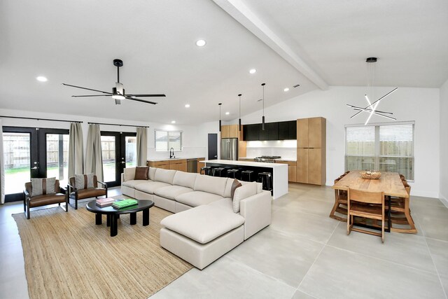 living room featuring french doors, lofted ceiling with beams, ceiling fan with notable chandelier, and sink