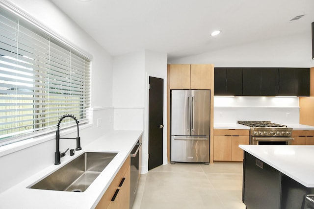 kitchen with sink, premium appliances, vaulted ceiling, light brown cabinetry, and light tile patterned flooring