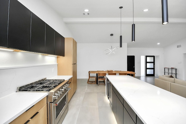 kitchen featuring hanging light fixtures, high end stove, light brown cabinetry, beamed ceiling, and light stone counters