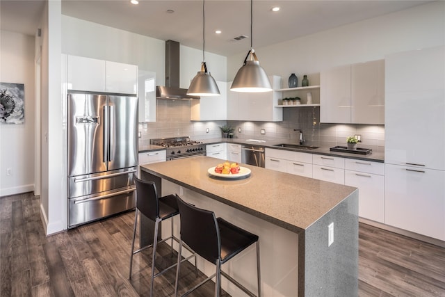 kitchen featuring white cabinetry, wall chimney exhaust hood, and high end appliances