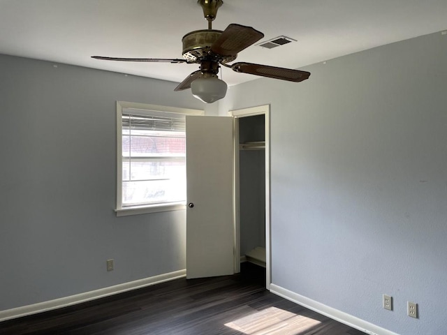 unfurnished room featuring ceiling fan and dark wood-type flooring