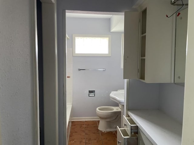 bathroom with tile patterned flooring, toilet, and a bathtub