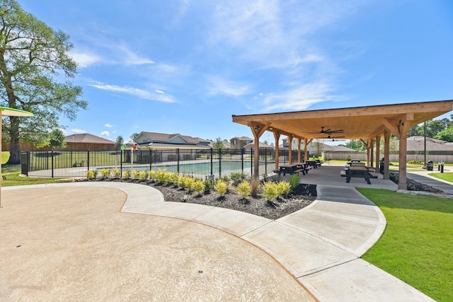 view of property's community featuring a swimming pool, a patio, and a lawn