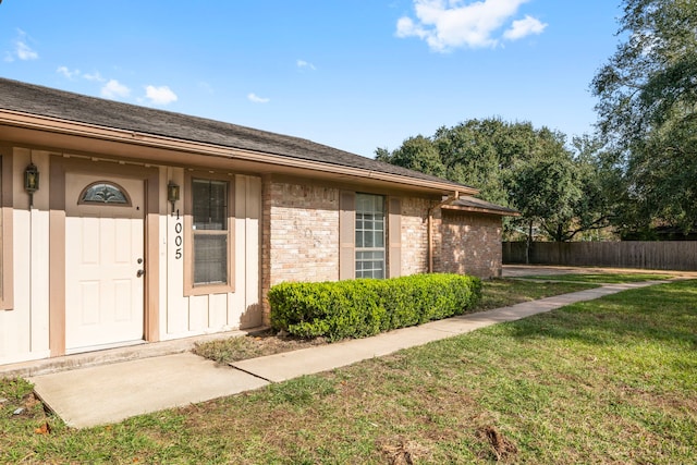 property entrance with a lawn