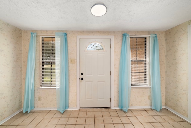 foyer featuring light tile patterned floors and a textured ceiling