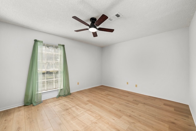 spare room featuring ceiling fan, a textured ceiling, and light hardwood / wood-style flooring