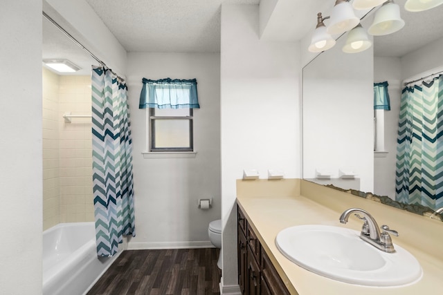 full bathroom with toilet, shower / tub combo with curtain, wood-type flooring, a textured ceiling, and vanity