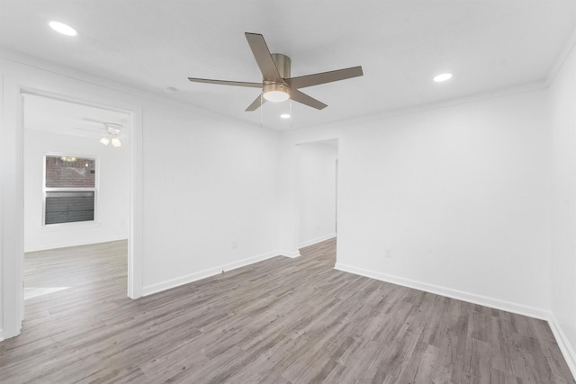 empty room with ceiling fan, ornamental molding, and light wood-type flooring