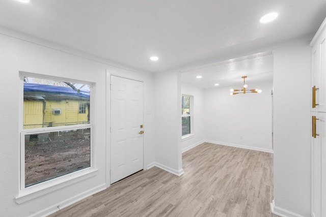 foyer with light hardwood / wood-style flooring and a chandelier