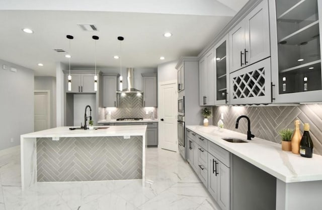 kitchen with gray cabinetry, wall chimney exhaust hood, stainless steel appliances, sink, and pendant lighting