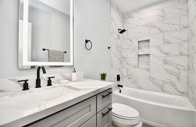 full bathroom with vanity, tiled shower / bath combo, and toilet