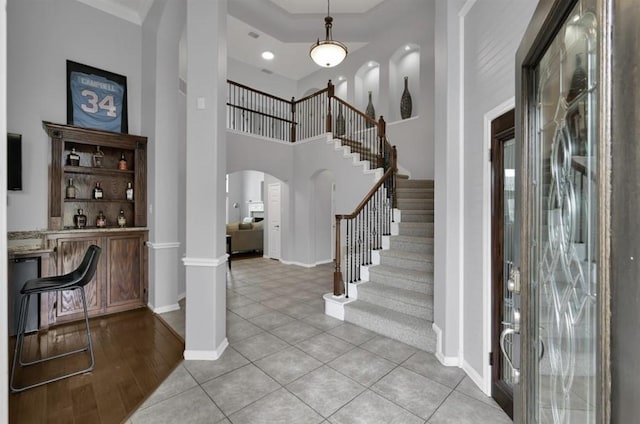 tiled foyer entrance with crown molding