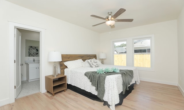 bedroom with ceiling fan, ensuite bathroom, and light wood-type flooring