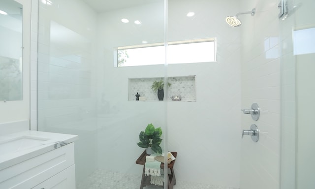 bathroom featuring a tile shower and vanity