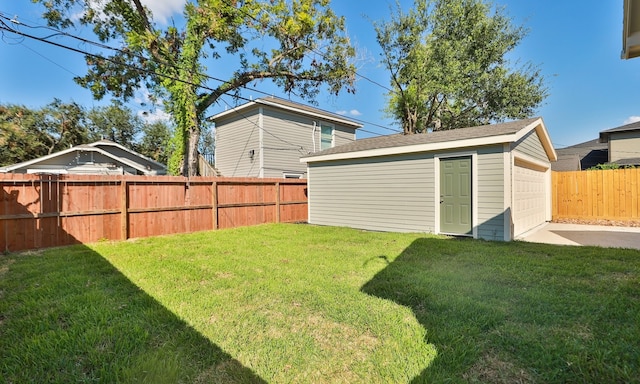 view of yard featuring a garage and an outbuilding