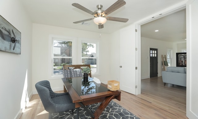 office with light hardwood / wood-style flooring and ceiling fan