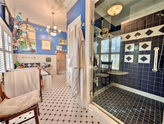 bathroom with a tile shower, a notable chandelier, and ornamental molding