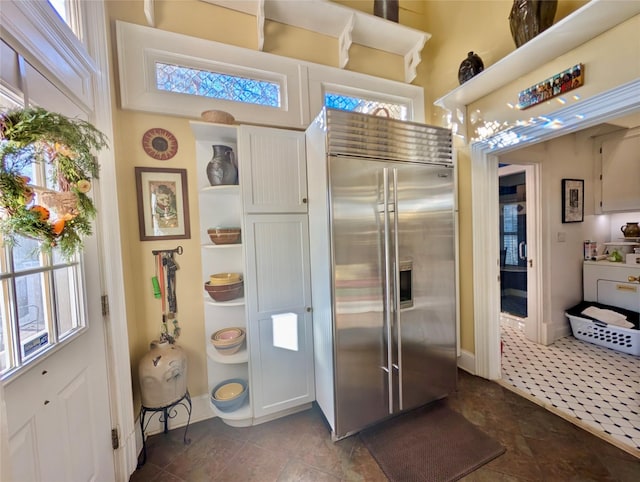 kitchen featuring stainless steel built in fridge and dark tile patterned flooring