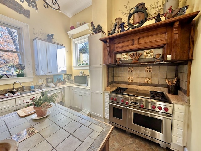 kitchen featuring white cabinetry, tile counters, sink, stainless steel appliances, and plenty of natural light